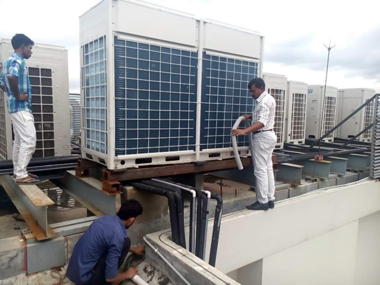 Technicians installing rooftop VRF outdoor condensing units