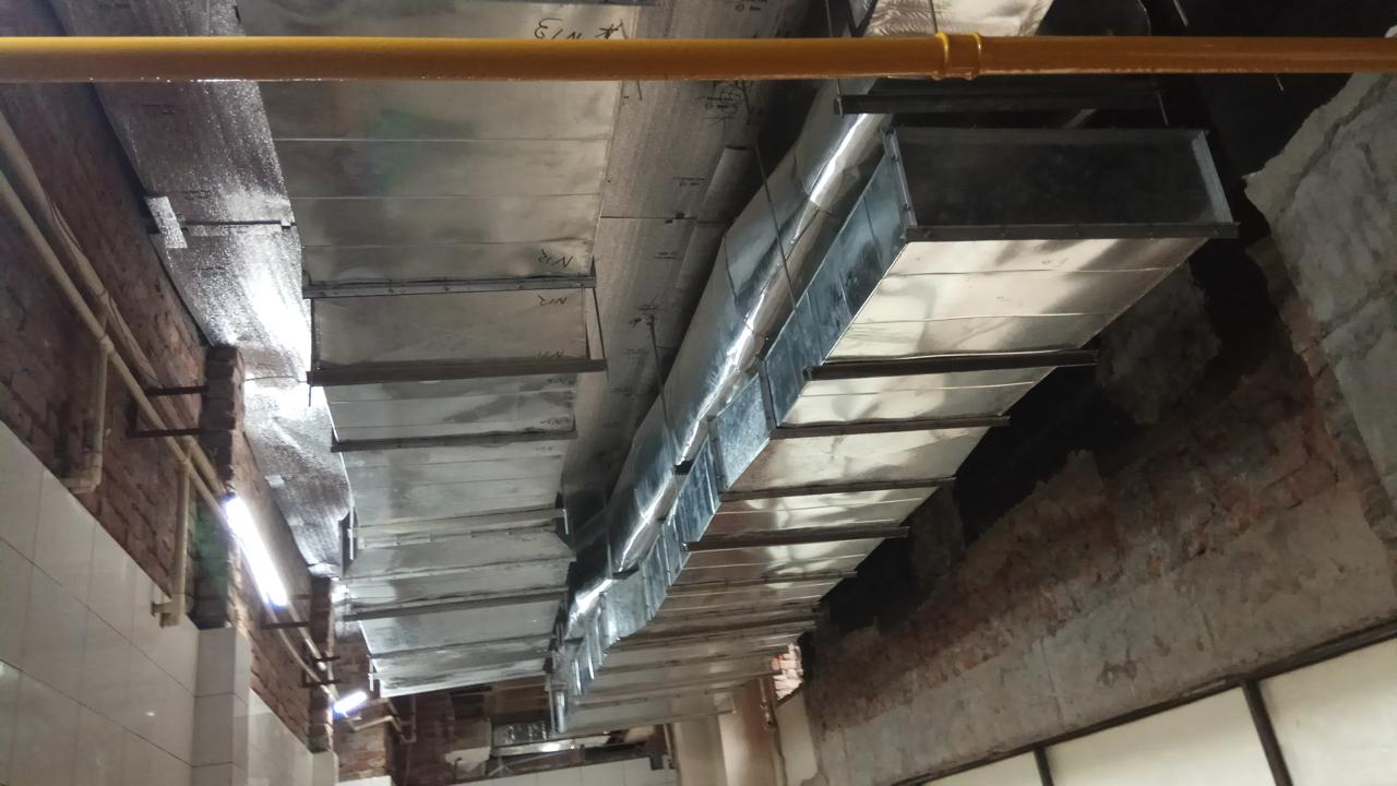 Galvanised sheet metal supply ducting suspended from a building ceiling