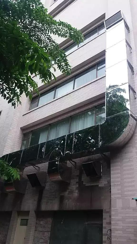 Building exterior with installed exhaust ducting and ventilation outlets on the facade